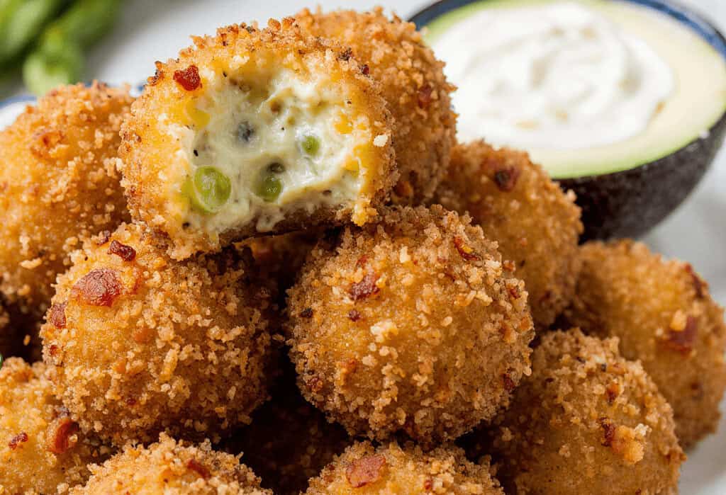 Crispy cream cheese avocado bites with green peas, served with a side of creamy dip and fresh avocado slices, perfect appetizer for parties and healthy snack options.