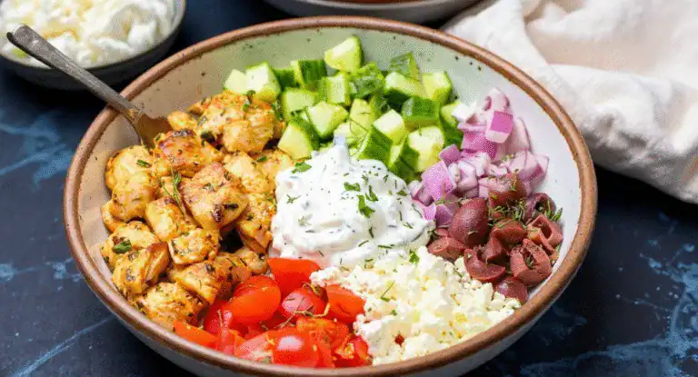Grilled chicken salad with fresh cucumbers, cherry tomatoes, red onions, feta cheese, and creamy dressing, perfect for healthy eating and meal prep options.