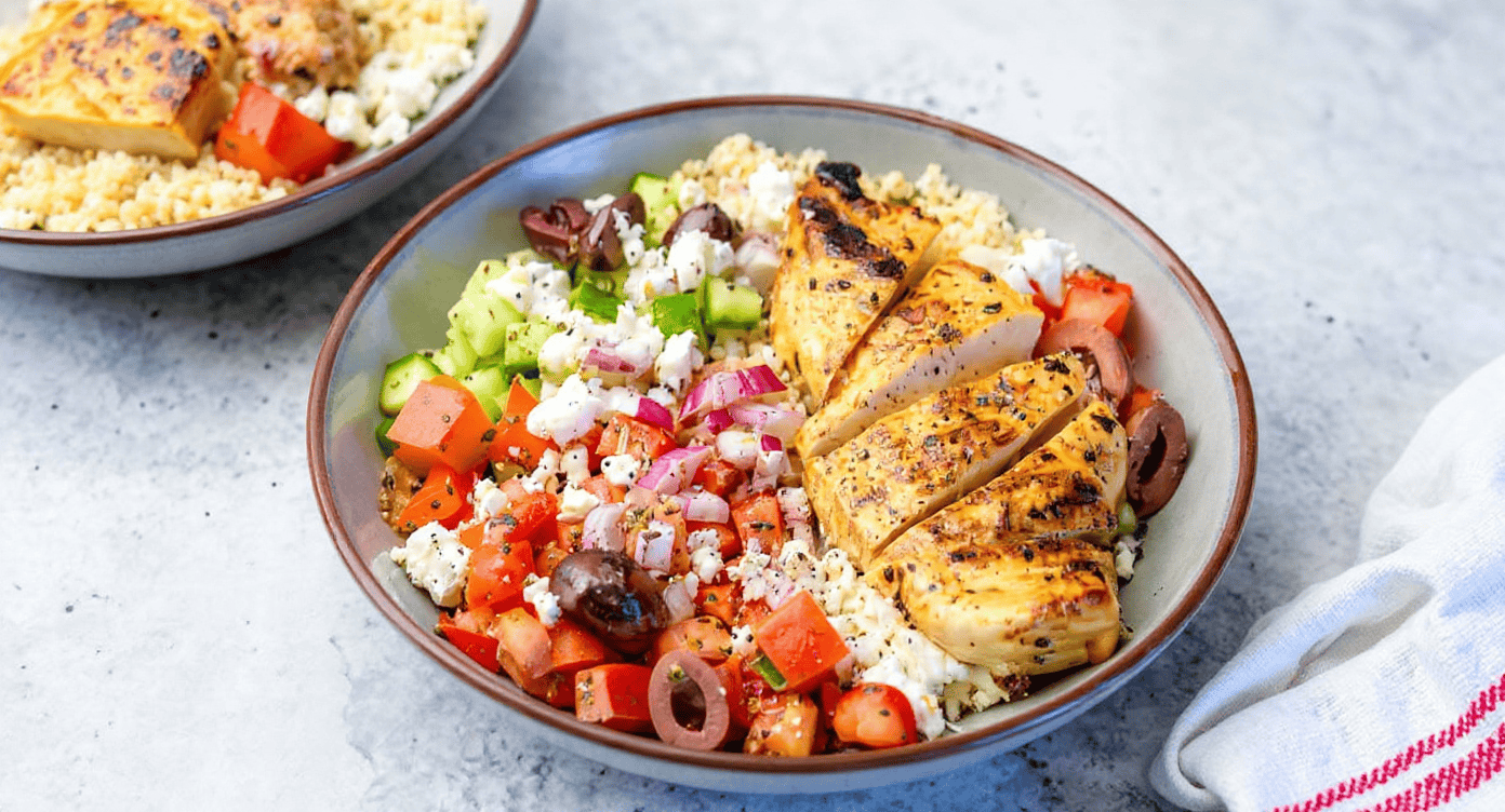 Juicy grilled chicken breast with fresh vegetables and feta cheese in a colorful Mediterranean-inspired salad bowl. Perfect for healthy meals and meal prep.