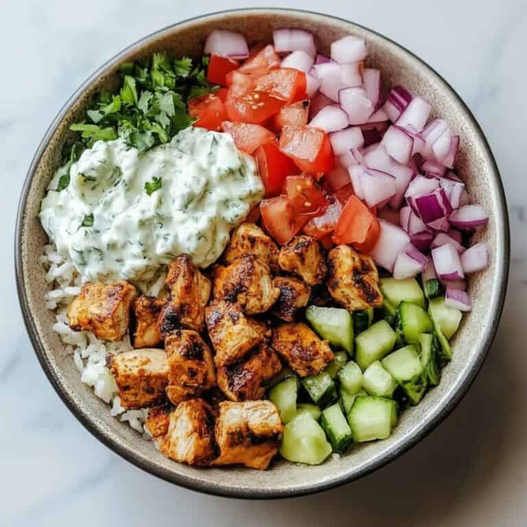Fresh chicken salad bowl with chopped cucumbers, tomatoes, onions, herbs, and creamy dressing, perfect for a healthy meal at home or on the go. Delicious and colorful, ideal for lunch or dinner.