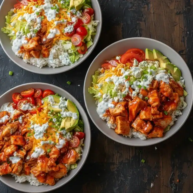 Delicious chicken burrito bowls with rice, fresh vegetables, avocado, shredded cheese, and creamy dressing for a flavorful meal. Perfect for lunch or dinner, packed with wholesome ingredients.